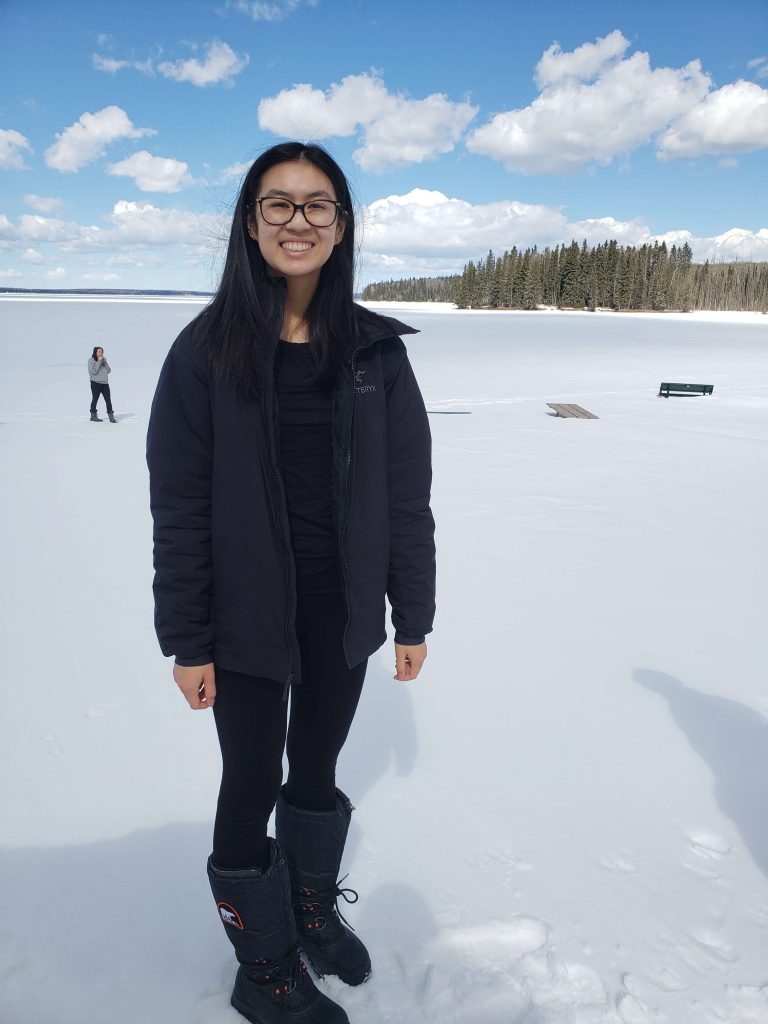 Carolyn Gao, UBC Forestry Co-op student, smiling while standing in snow. 