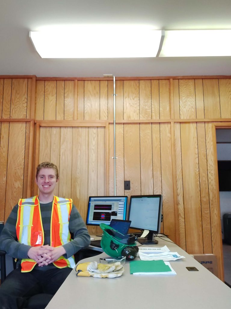 Colin Hillmer, UBC Forestry Co-op Student, sitting at his desk while working. 
