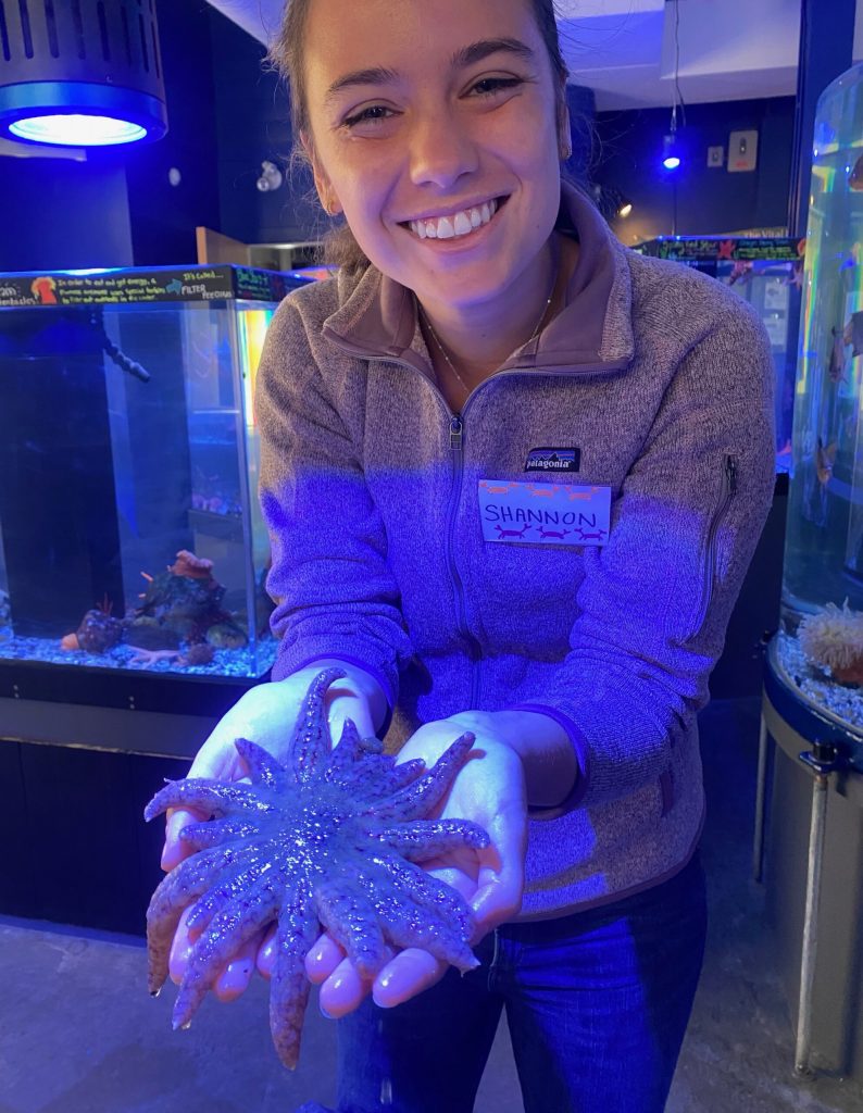 Shannon holding a starfish and smiling.
