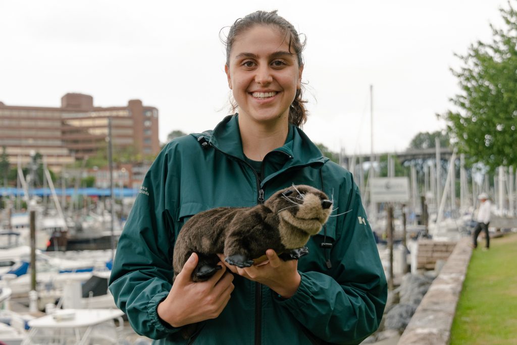 Maria holding an otter and smiling.