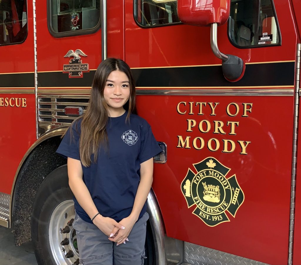 Daniella standing in front of a City of Port Moody Fire Rescue Truck.
